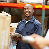 warehouse worker smiling holding tablet