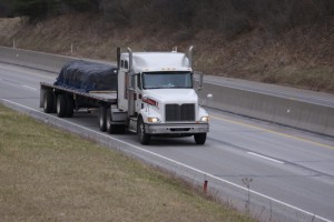 truck with flatbed trailer driving on highway