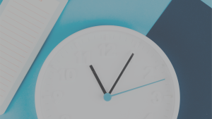 Close up of white clock with blue hands