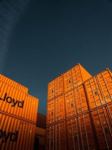 stack of orange shipping containers against a blue sky